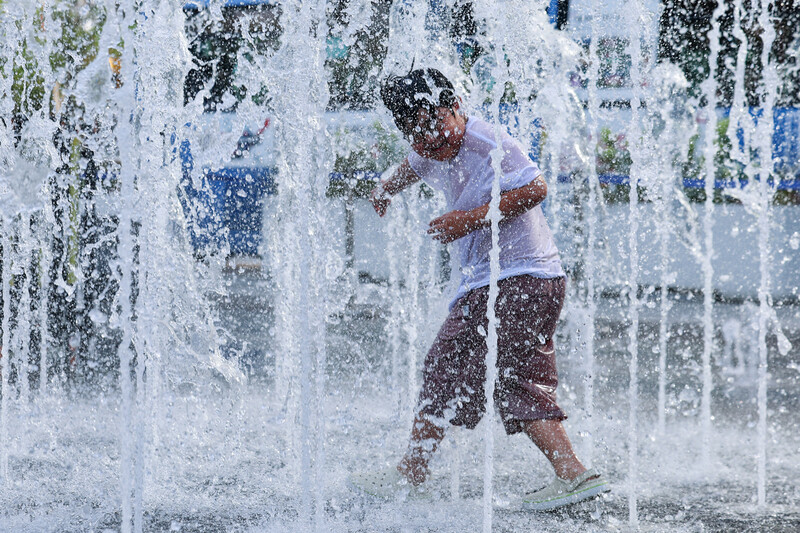 서울 한낮 기온이 33도까지 오른 21일 서울 종로구 광화문광장 분수에서 한 아이가 시원하게 물을 맞고 있다. 연합뉴스.