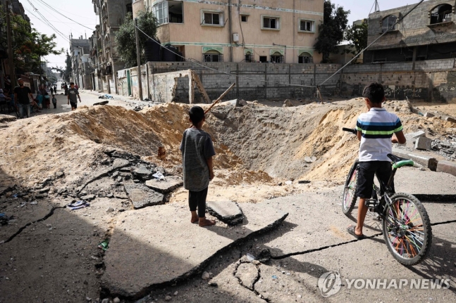 이스라엘군의 폭격으로 라파 시내에 패인 구덩이
(라파 AFP=연합뉴스) 18일(현지시간) 팔레스타인 가자지구 최남단도시 라파에서 어린이들이 이스라엘군의 폭격으로 거리에 패인 구덩이를 살펴보고 있다. 2024.5.18