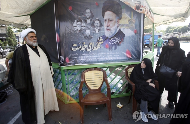 20일(현지시가) 이란 수도 테헤란에서 에브라힘 라이시 대통령의 초상화를 놓고 추도하는 시민들
[EPA=연합뉴스 자료사진. 재판매 및 DB 금지]