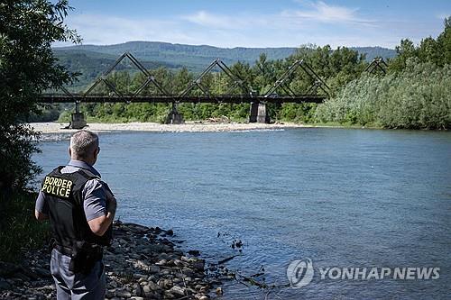 우크라이나와 루마니아 접경 지대를 흐르는 티사 강을 바라보는 루마니아 국경경찰 [AFP 연합뉴스 자료사진. 재판매 및 DB 금지]