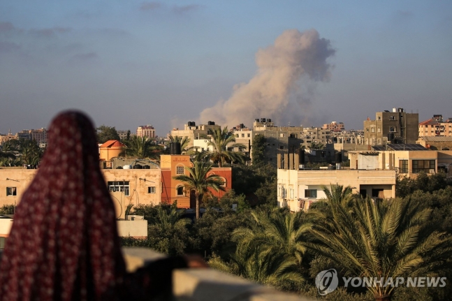 이스라엘군의 공습 이후 연기가 피어오르는 가자 최남단 도시 라파 상공을 지켜보는 팔레스타인 여성
[AFP 연합뉴스. 재판매 및 DB 금지]