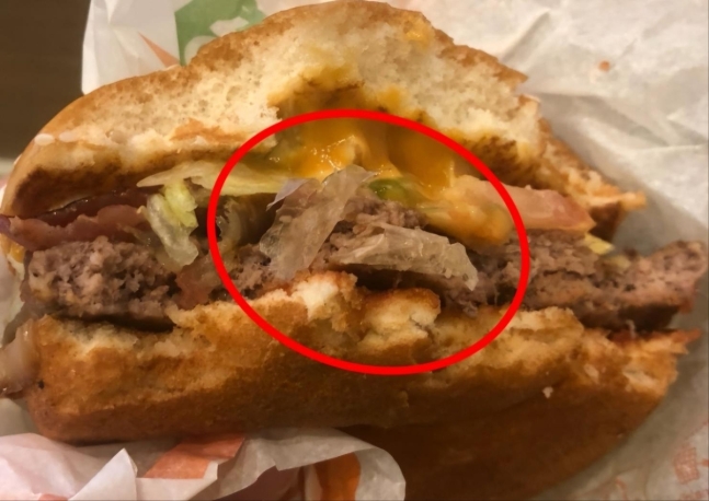 기름종이 넣어 만든 맥도날드 햄버거
 동그라미 안의 하얀 물체는 야채처럼 보이지만 기름종이여서 잘 안 씹힌다고 한다. 고기 패티를 분류해 놓아두는 종이인데, 햄버거를 만들 때 패티에 붙어있는 것을 제거하지 않고 함께