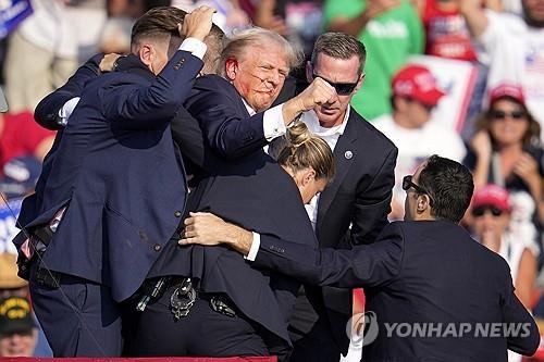 귀에 피묻은 상태로 급히 퇴장하는 트럼프 
[AP=연합뉴스]