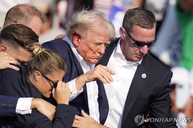 총격당한 트럼프 전 미국 대통령을 대피시키는 경호요원들
[버틀러[미 펜실베이니아주] AP=연합뉴스)