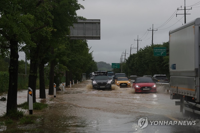 침수된 판문점 가는 길 (파주=연합뉴스) 임병식 기자 = 경기북부 접경지에 호우경보가 내린 17일 오전 경기도 파주시 문산읍에서 1번 국도가 일부 물에 잠겨 차량이 침수 지대를 피해 거북이 운행을 하고 있다. 202