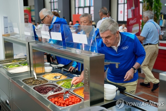 올림픽 선수촌의 채식 메뉴를 담는 토마스 바흐 IOC 위원장 [AFP=연합뉴스]