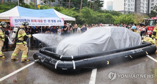전기차 화재 진압 시연
(인천=연합뉴스) 임순석 기자 = 13일 오전 인천 연수구 송도 2동 행정복지센터 주차장에서 열린 전기자동차 화재대응 민·관 합동 교육에서 소방관들이 질식소화포와 전기차 수조탱크를 이용한 전기
