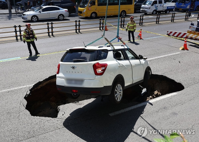 성산로에 땅꺼짐 발생, 옮겨지는 사고차량 (서울=연합뉴스) 서대연 기자 =  29일 오전 서울 서대문구 연희동 성산로에서 발생한 땅 꺼짐 사고로 빠져버린 승용차가 크레인으로 옮겨지고 있다. 2024.8.29 dwis