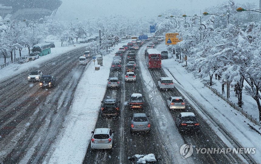 험난한 출근길 (수원=연합뉴스) 홍기원 기자 = 이틀째 수도권 폭설이 이어지고 있는 28일 오전 경기도 수원시 팔달구 수원월드컵경기장 부근에서 차량이 서행하고 있다. 2024.11.28 xanadu@yna.co.kr