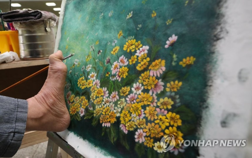 Art Created by Foot
(Seoul=Yonhap News) On April 19, 2018, a day before the 38th Day of Persons with Disabilities, Kim Kyung-ah, a mouth and foot painting artist, is drawing at the '2018 Songpa District Disabled Festival' held at Songpa District Civic Center in Samjeon-dong, Songpa-gu, Seoul. [