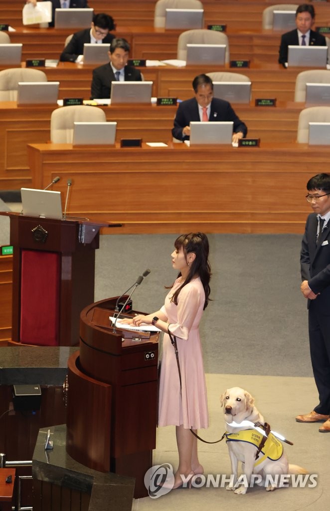 김예지 의원과 안내견 조이
(서울=연합뉴스) 한상균 기자 = 2023년 6월 14일 국민의힘 김예지 의원이 국회 본회의에서 대정부 질문을 하고 있다. 김 의원 옆은 안내견 조이. [연합뉴스 자료사진] 2025.2.2