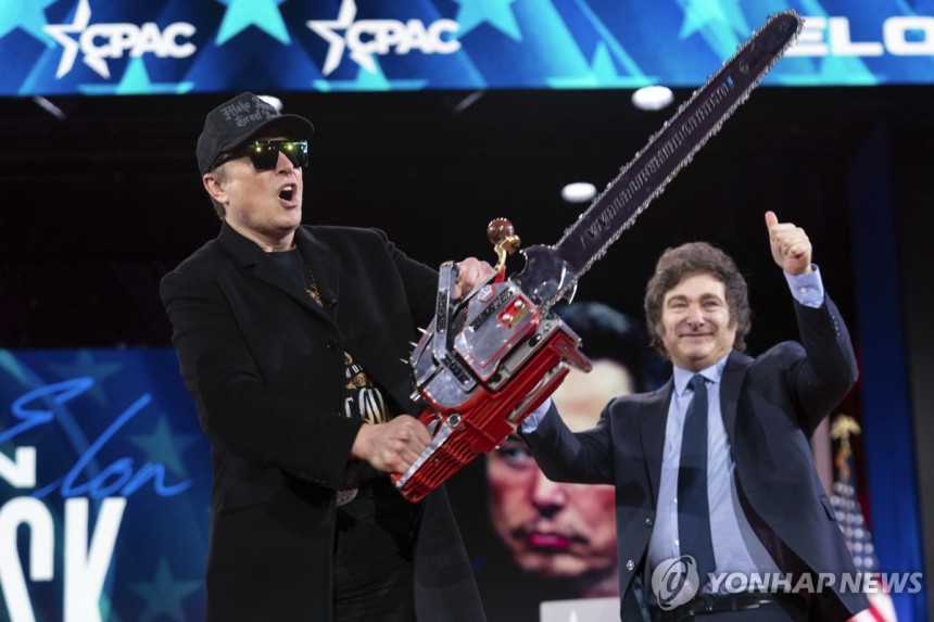 전기톱 휘두르는 머스크 [AP=연합뉴스 자료사진]