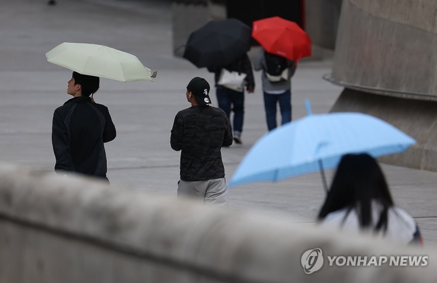 서울에 내리는 비 (서울=연합뉴스) 김성민 기자 = 서울에 비가 내린 1일 오전 서울 중구 동대문디자인플라자(DDP)에서 시민들이 비를 피하고 있다.2025.5.1 