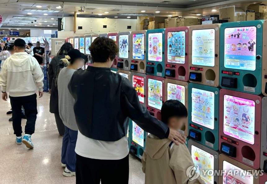 어떤 가챠를 해볼까 (서울=연합뉴스) 김유진 인턴기자 = 지난달 27일 오후 서울 서초구의 국제전자센터에서 한 여성이 아이와 함께 가챠(캡슐 토이)를 구경하고 있다.2025.5.5