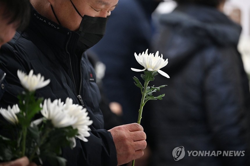 희생자에 헌화하는 제주항공 참사 유가족 (무안=연합뉴스) 정다움 기자 = 제주항공 여객기 참사 49일째인 15일 오전 전남 무안국제공항 분향소에서 열린 49재 합동위령제에서 유족들이 헌화하고 있다.2025.2.15
