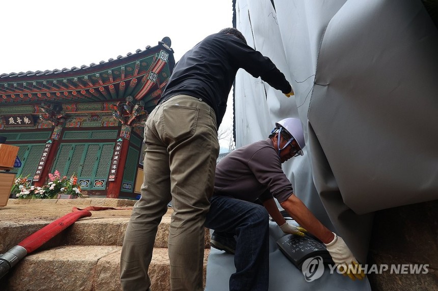 대전사 보광전 방염포 설치 (청송=연합뉴스) 김도훈 기자 = 27일 경북 청송군 주왕산면 대전사에서 관계자들이 보광전에 방염포를 설치하고 있다.밤사이 주왕산을 통해 번지던 불은 새벽부터 잦아들어 사찰로 번