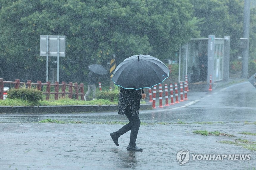 거센 봄비 쏟아진 제주 (서귀포=연합뉴스) 박지호 기자 = 호우특보가 내려진 22일 오전 제주 서귀포시 남원읍 하례리 입구에서 우산을 쓴 시민들이 길을 가고 있다.2025.4.22 