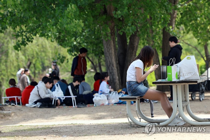 가벼운 옷차림으로 (서울=연합뉴스) 신현우 기자 = 낮 동안 초여름 날씨를 보인 지난 8일 서울 영등포구 여의도한강공원을 찾은 시민이 가벼운 옷차림으로 휴식하고 있다.2025.5.8 