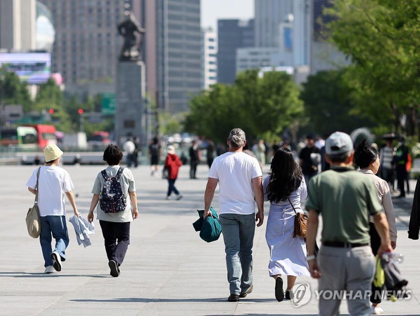 ‘외투 안녕’(서울=연합뉴스) 윤동진 기자 = 초여름 날씨를 보인 12일 서울 광화문 광장에서 관광객과 시민들이 외투를 벗은 채 걷고 있다.2025.5.12 