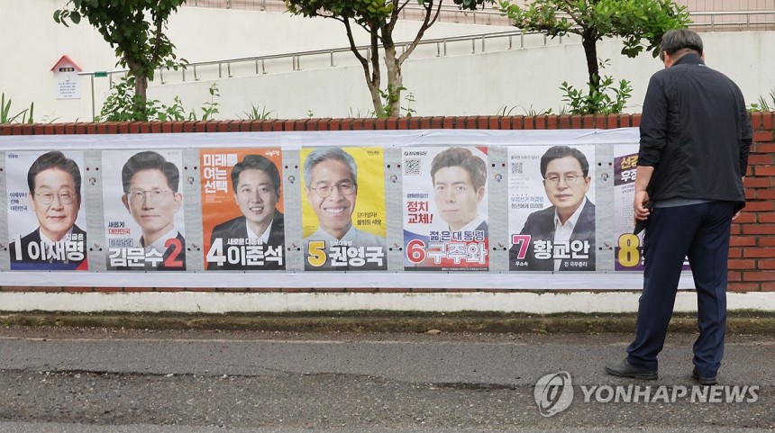 '누구를 뽑을까'
(전주=연합뉴스) 나보배 기자 = 제21대 대통령 선거 벽보 부착을 시작한 15일 전주시 완산구 효자1동 주민센터 앞에서 한 시민이 벽보를 보고 있다. 2025.5.15 warm@yna.co.kr