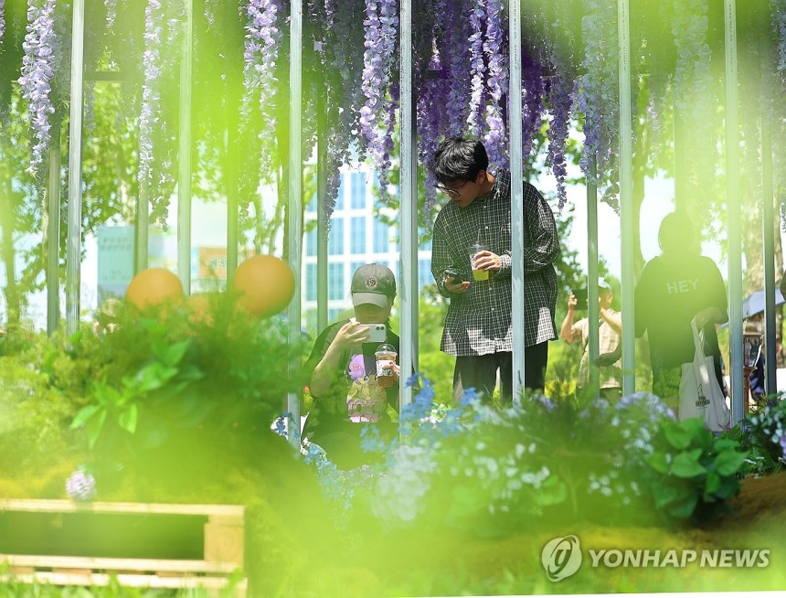서울국제정원박람회 개막
(서울=연합뉴스) 김도훈 기자 = 22일 서울 동작구 보라매공원에서 열린 2025 서울국제정원박람회를 찾은 시민들이 등나무 터널에서 사진을 찍고 있다.
    올해 10회째를 맞이한 이번 전시