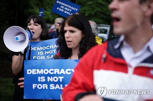 트럼프 밈코인 행사에 항의하는 시위대
(스털링&lt;미 버지니아주&gt; AFP=연합뉴스) 2025년 5월 22일 미국 버지니아주 스털링의 트럼프 내셔널 골프 클럽에서 열리는 비공개 만찬 행사에 항의하는 시위 참가자