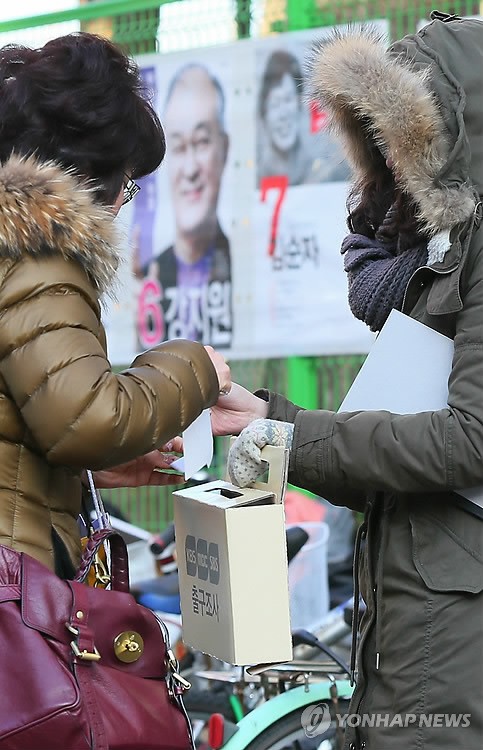 &lt;2012대선&gt; '지금은 출구조사 중'
 (서울=연합뉴스) 한종찬 기자 = 18대 대통령선거일인 19일 서울 잠실본동 주민센터에 마련된 투표소 앞에서 출구 조사원들이 투표를 마치고 나오는 시민에게 출구조사