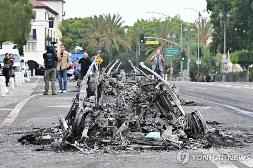 9일 오전 LA 도심에서 웨이모 차량이 불에 타 재만 남은 모습  
[AFP=연합뉴스. 재판매 및 DB 금지]