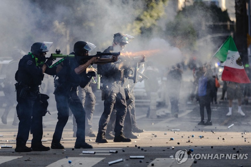 지난 8일 LA 도심 시위 현장에서 공포탄 등을 발포하는 경찰 
[AFP=연합뉴스. 재판매 및 DB 금지]