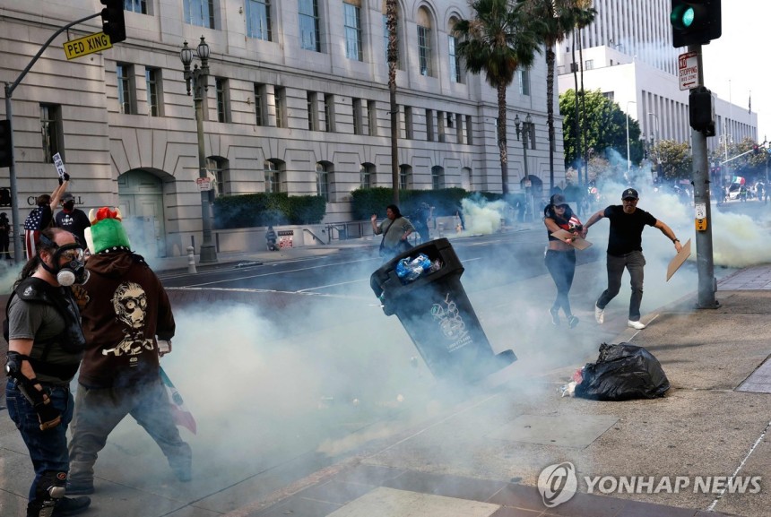 14일 LA 시청 앞 거리에서 최루탄으로 시위대를 해산시키는 경찰
[AFP=연합뉴스. 재판매 및 DB 금지]