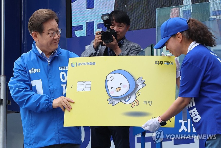 지역화폐 모형 전달받는 이재명 후보
(파주=연합뉴스) 김주성 기자 = 더불어민주당 이재명 대선 후보가 20일 경기 파주시 금릉역 중앙광장에서 열린 유세에서 지역화폐 모형을 전달받고 있다. 2025.5.20 utzza