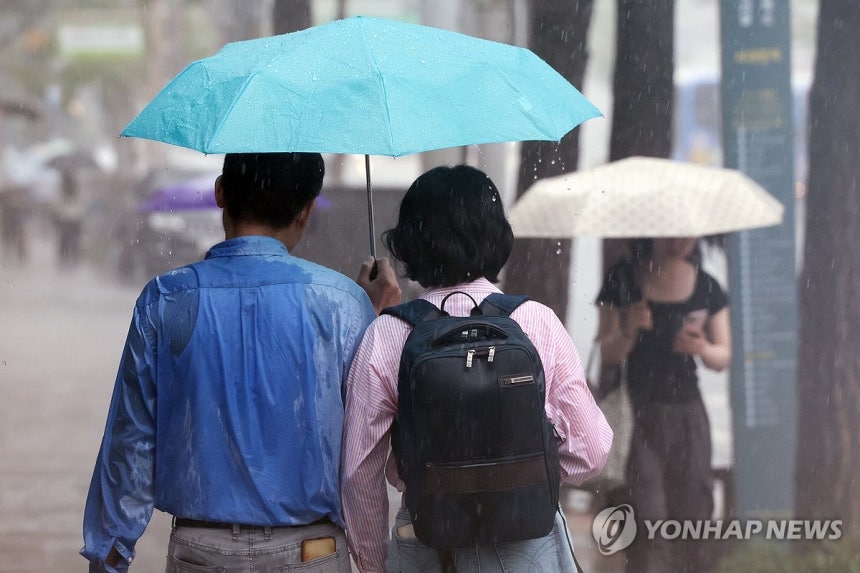 서울 서대문구에서 상의가 비에 젖은 시민이 우산을 쓰고 이동하고 있다. [연합뉴스 자료사진]