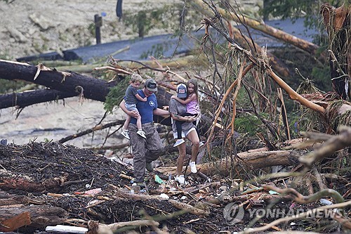 폭우 잔해 위로 걸어가는 텍사스 주민들 
[AP=연합뉴스 자료사진 재판매 및 DB금지]