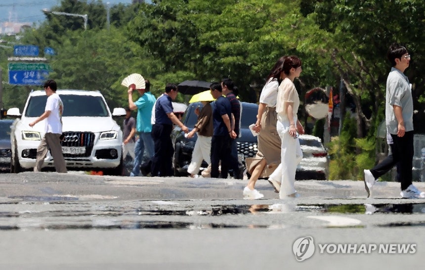 폭염에 아지랑이 피어오르는 도로
(광주=연합뉴스) 조남수 기자 = 전국 대부분 지역에 폭염 특보가 발효된 3일 광주 서구 치평동에서 시민들이 강렬한 햇빛에 달구어져 아지랑이가 피어오르는 도로를 걷고 있다. 2025.