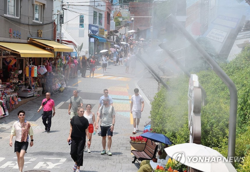 더위 식히는 쿨링 포그
(부산=연합뉴스) 강선배 기자 = 전국 대부분 지역에 폭염경보 또는 폭염주의보가 내려진 가운데 8일 오후 부산 사하구 감천문화마을에서 외국인 관광객들이 쿨링 포그가 뿜어내는 물안개를 맞고 있다