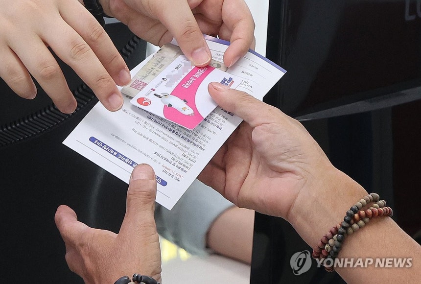 민생회복 소비쿠폰 2차 신청 첫날 (부산=연합뉴스) 강선배 기자 = 민생회복 소비쿠폰 2차 신청 첫날인 22일 부산 부산진구 가야2동 주민센터에서 어르신들이 지원금을 받고 있다. 지급 대상은 가구 합산 소득 상위 1