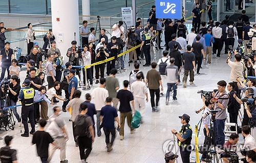 &#37320;放されて仁川&#22269;際空港に到着した韓&#22269;人&#21172;&#20685;者たち＝１２日、仁川（聯合ニュ&#12540;ス）