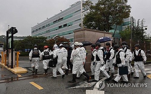 Officials from the fire service, police and the National Forensic Service enter the National Informa