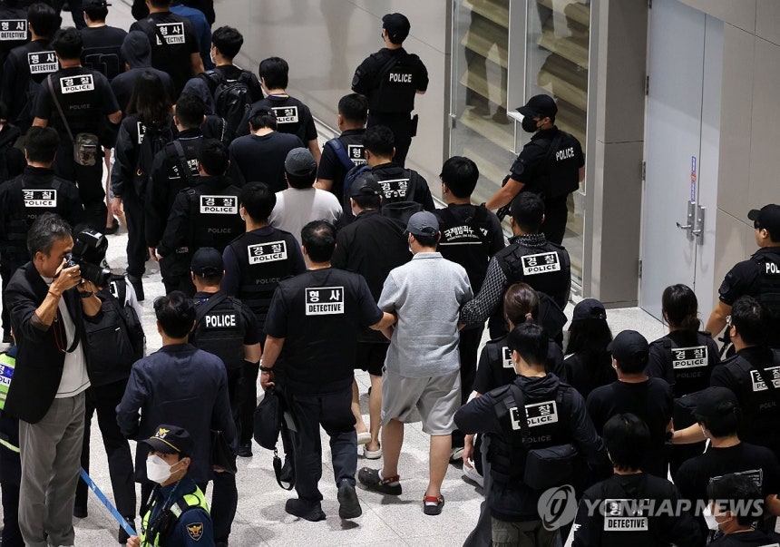 캄보디아에서 인천공항으로 호송된 한국인 구금자들(영종도=연합뉴스) 김성민 기자 = 캄보디아 온라인 사기에 가담해 구금된 한국인들이 지난 18일 오전 인천국제공항 제2터미널을 통해 송환되고 있다. 이날 송환에는 경찰