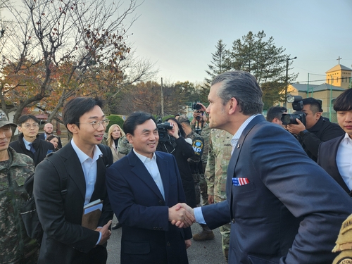 South Korean Defense Minister Ahn Gyu-back (C) shakes hands with U.S. Defense Secretary Pete Hegseth