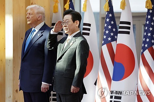 President Lee Jae Myung (R) salutes as he stands alongside U.S. President Donald Trump as they atten