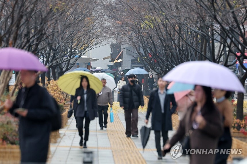 비 (서울=연합뉴스) 임화영 기자 = 서울 종로구 광화문네거리에서 우산을 쓴 시민들이 이동하고 있다.2025.11.25 