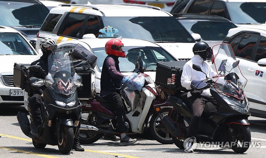 (서울=연합뉴스) 김도훈 기자 = 9일 서울 강남역 사거리에서 배달라이더들이 교통신호를 기다리고 있다.2025.6.9 