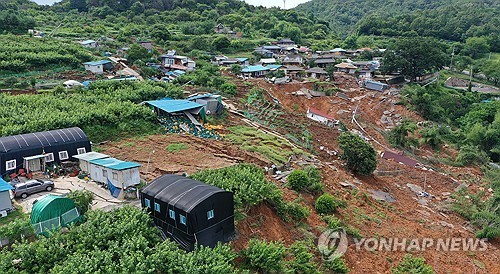 지난 7월 21일 경남 산청군 생비량면 상능로 산기슭에 위치한 일대 마을이 최근 발생한 집중호우·산사태 여파로 매몰돼 있다.일부 주택은 흙과 잔해 위에 눕혀지고,일부는 완전히 매몰돼 지붕만 보이는 등 마