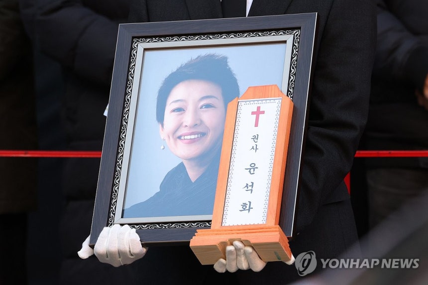 배우 윤석화 마지막 길,대학로서 노제 (서울=연합뉴스) 강민지 기자 = 21일 서울 종로구 한예극장 앞에서 열린 배우 윤석화의 노제에서 유가족이 영정을 들고 있다.2025.12.21 