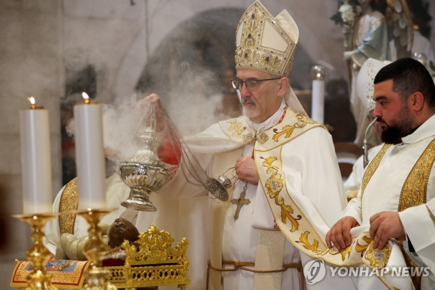 (로이터=연합뉴스) 25일 서안지구 베들레헴의 예수 탄생 교회에서 가톨릭 교회 예루살렘 라틴 총대주교인 피에르바티스타 피차발라 추기경이 자정 미사를 집전하고 있다.
