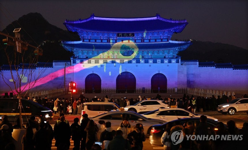 빛으로 물든 광화문 (서울=연합뉴스) 한종찬 기자 = 14일 서울 광화문광장에서 시민들이 초대형 미디어파사드 전시 '2025 서울라이트 광화문'을 관람하고 있다.2025.12.14 