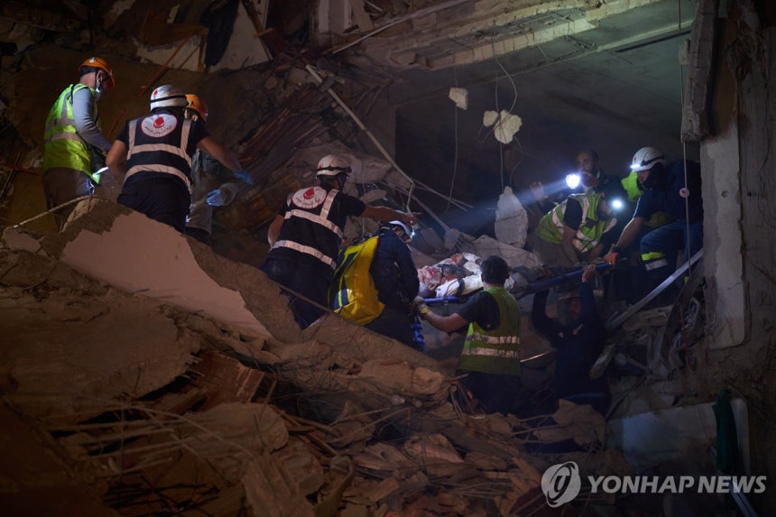 이스라엘 공습으로 붕괴한 레바논 베이루트의 건물에 부상자를 구출하는 응급대원들 [AP 연합뉴스. 재판매 및 DB 금지]