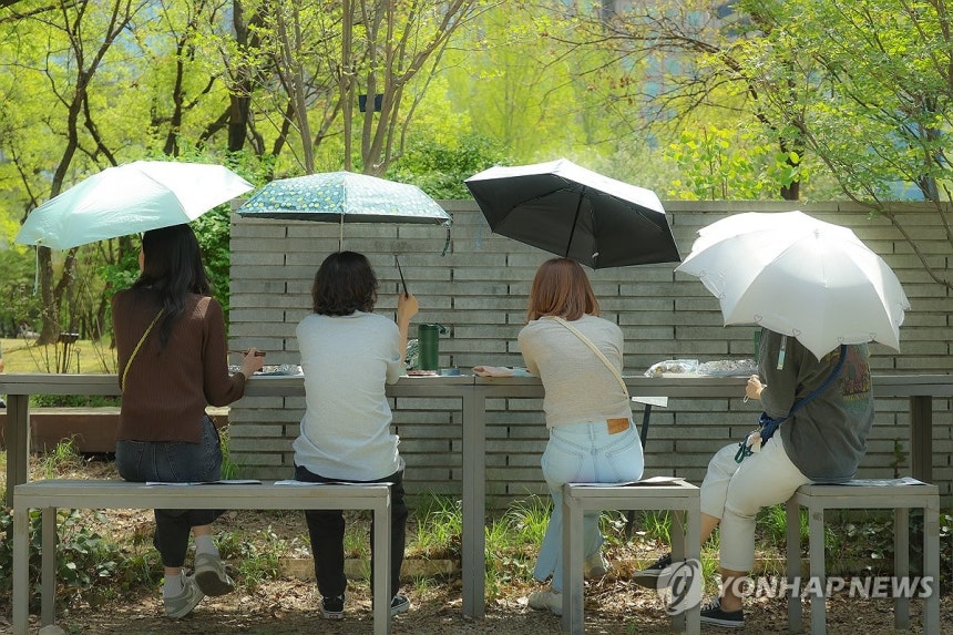 소풍 (서울=연합뉴스) 임화영 기자 = 초여름 날씨를 보인 16일 서울 여의도공원을 찾은 시민들이 양산 아래 점심 식사를 즐기고 있다.2026.4.16 