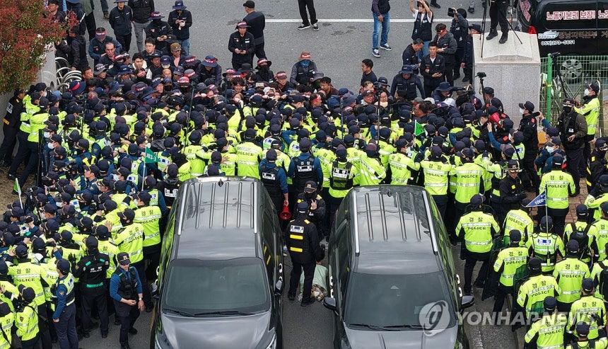 화물연대와 경찰 '대치' (진주=연합뉴스) 김동민 기자 = 20일 오후 경남 진주시 정촌면 BGF로지스 진주센터에서 화물연대 관계자가 센터 입구로 진입하려는 과정에서 경찰과 대치하고 있다.이날 센터 입구에